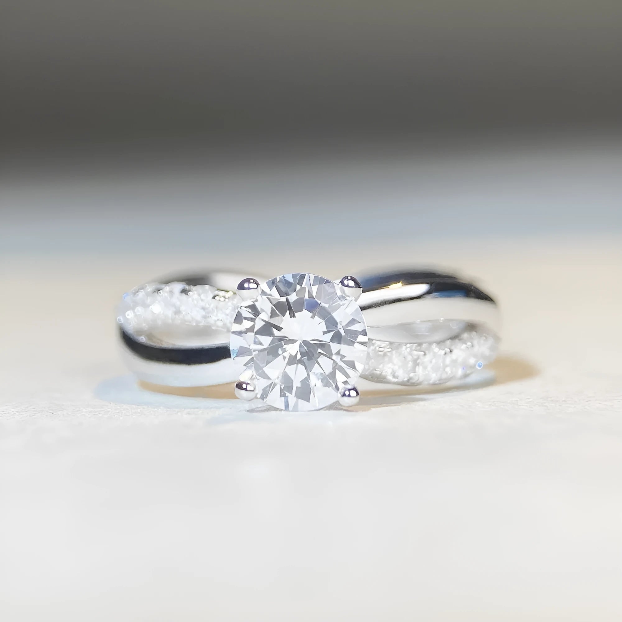 Silver ring with 1 karat moissanite stone in four-claw setting and twisted geometric arms