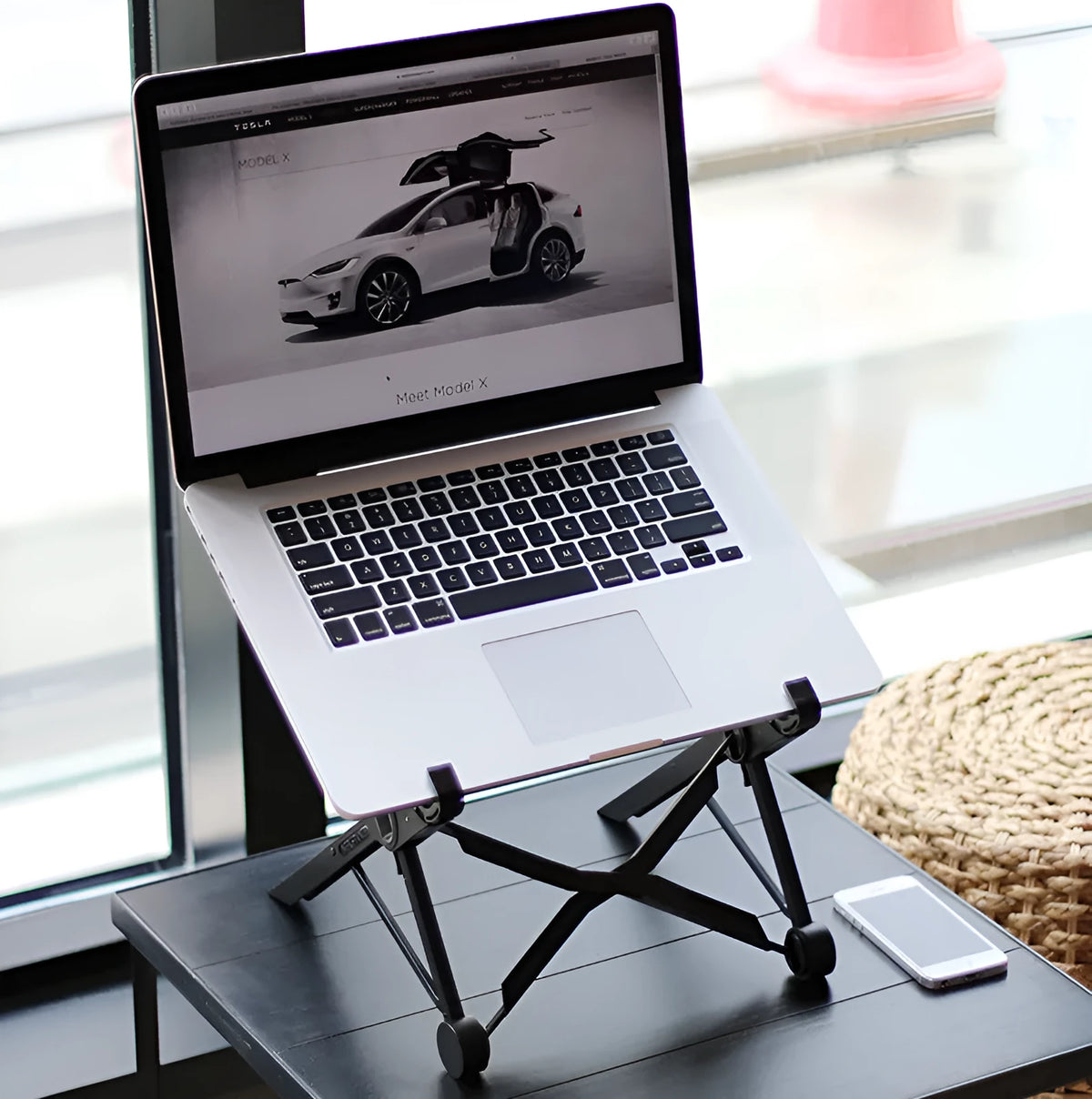 Black folding portable laptop stand with reinforced nylon construction showing adjustable height mechanism