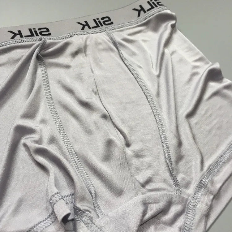 Men's loose fitting silk shorts in navy blue, shown on a mid-waist.