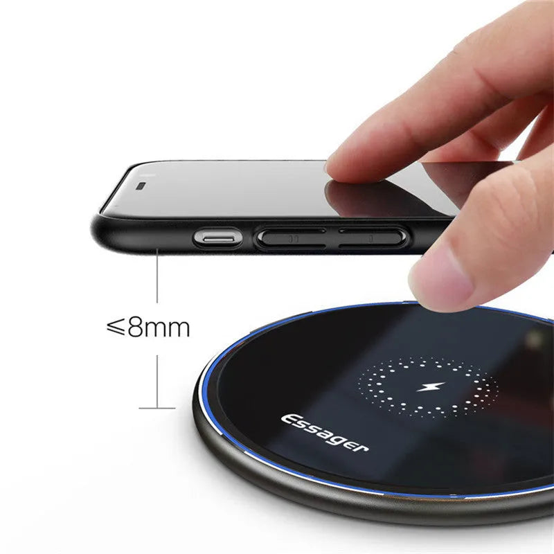 Black 15W Qi fast wireless charging pad with aluminium body and LED light, shown next to a smartphone.