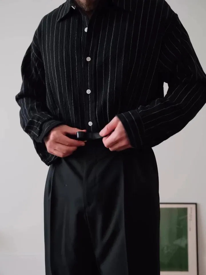 Black pinstriped button-down polyester shirt with a regular fit on a hanger.