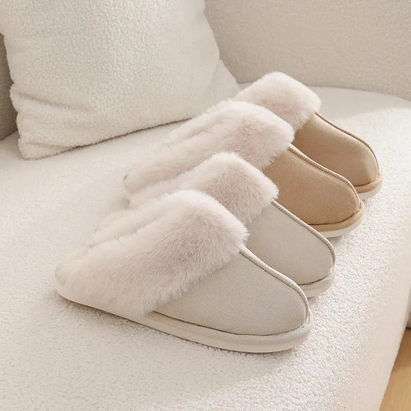 A pair of plush indoor slippers with a round toe, flat heel, and stitching detail, shown in one of five available colours.
