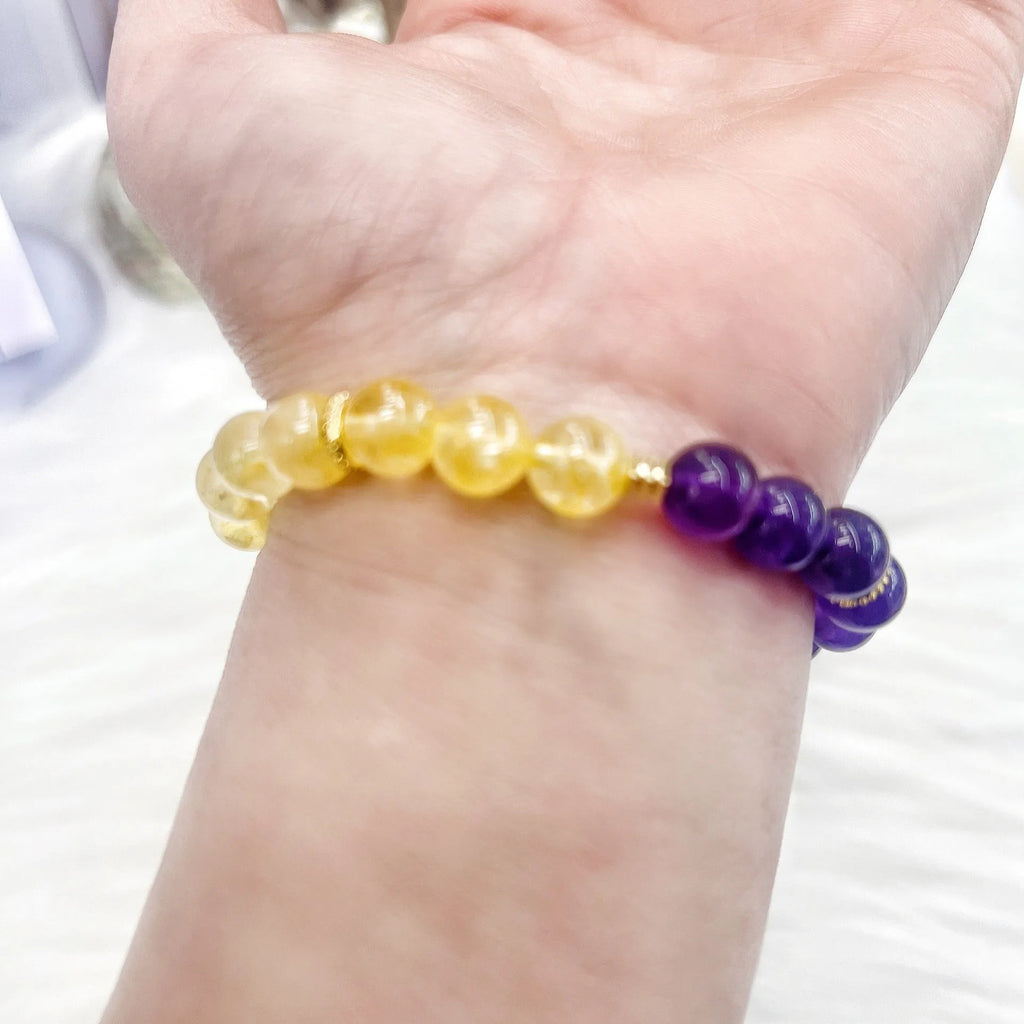Handmade women's yellow and purple crystal bracelet with amethyst beads on wrist