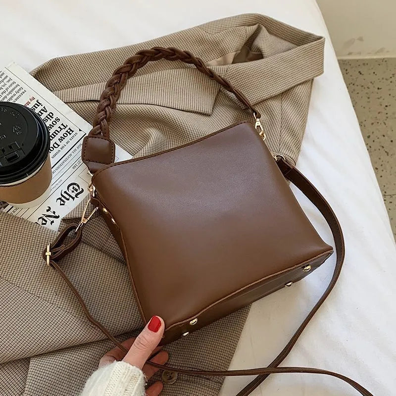 Woven texture PU leather crossbody bucket bag in neutral colour showing one-shoulder underarm carrying design