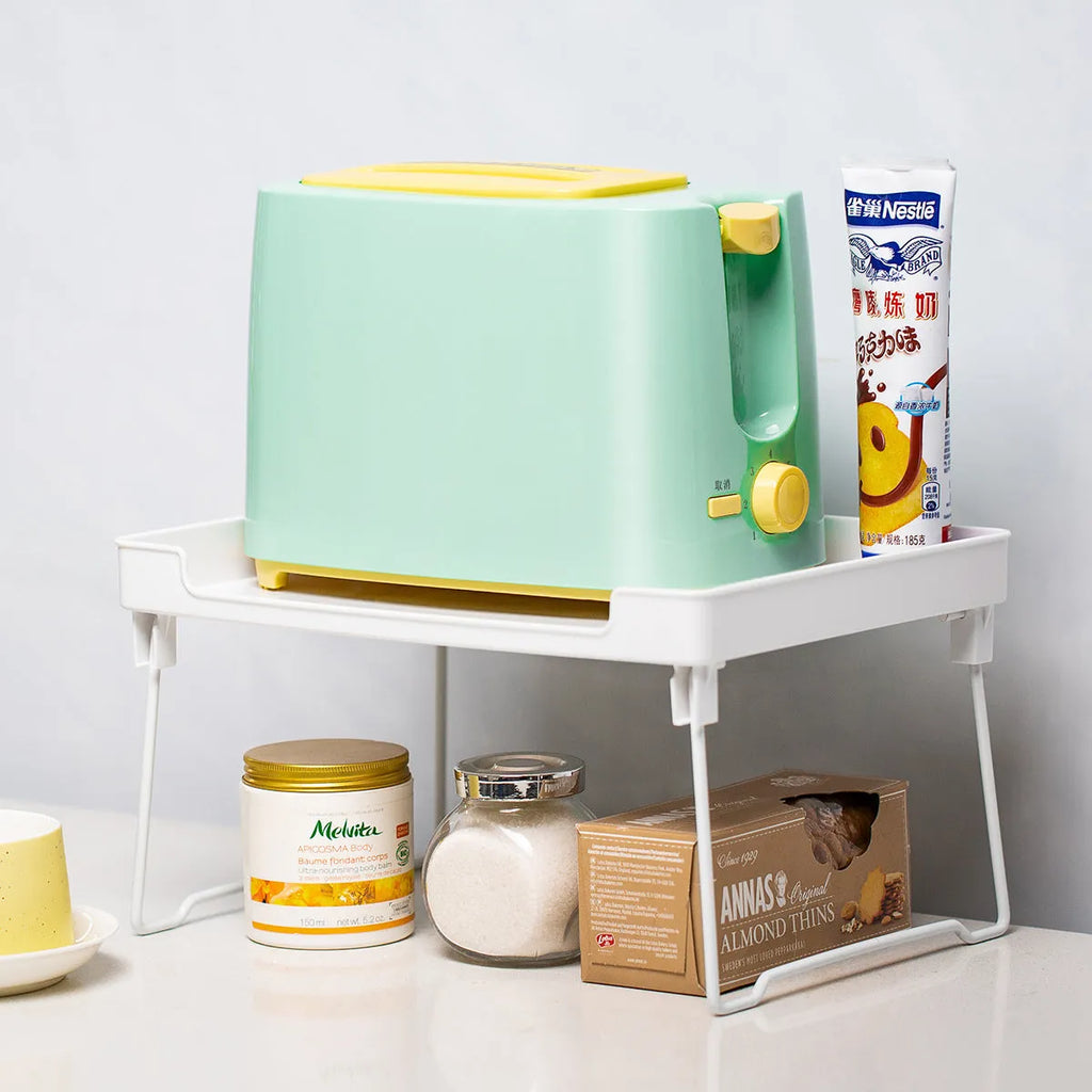 A transparent or white plastic kitchen supplies rack for organising utensils on a desktop or in a cupboard.