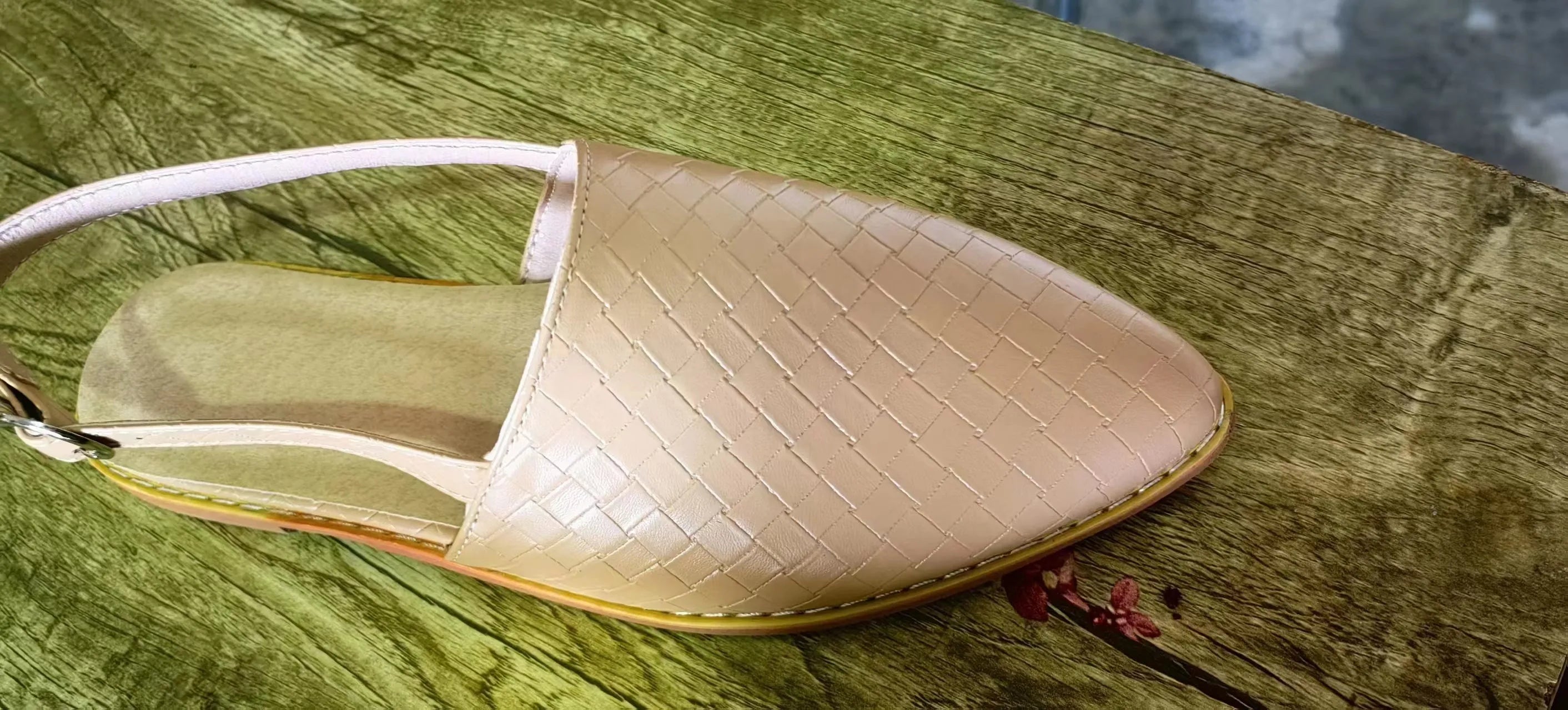 Women's black flat sandals with a silver buckle and pointed toe on a rubber sole.