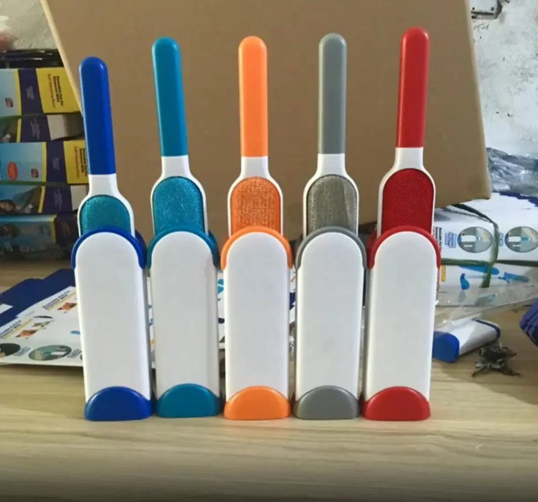 Blue reusable pet hair removal brush with double-sided adhesive head next to its self-cleaning base.