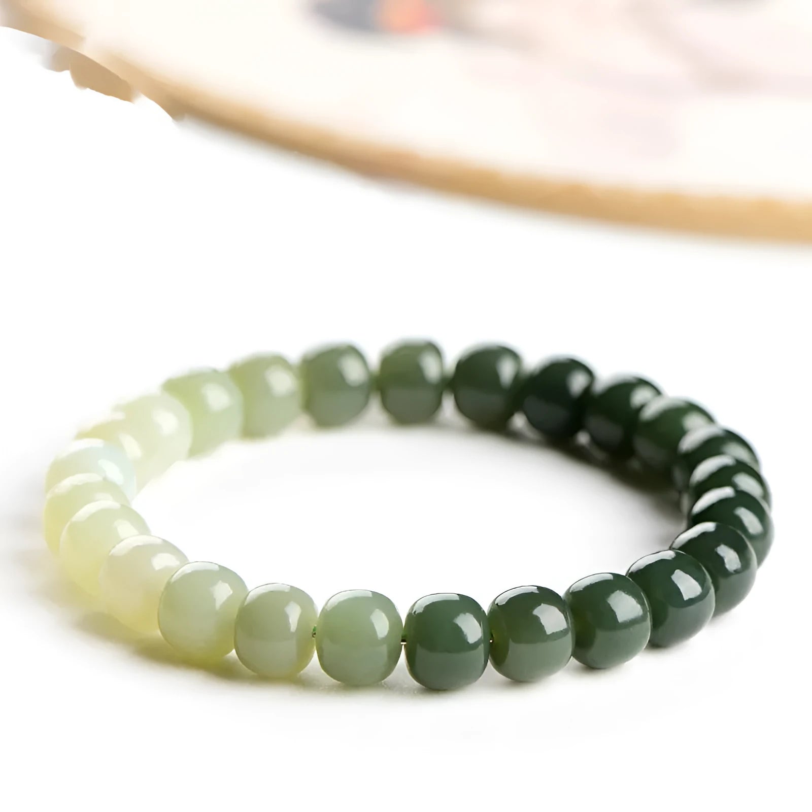 Natural Hetian jade bracelet showing a clear water gradient colour on polished beads.