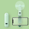 Green folding mini fan with plastic blades collapsed for compact storage