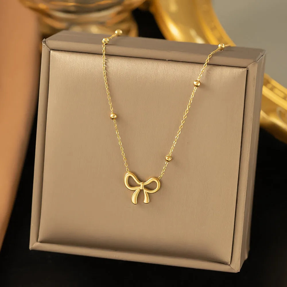 Gold-coloured women's bow necklace with cross chain design on adjustable 41-50cm perimeter