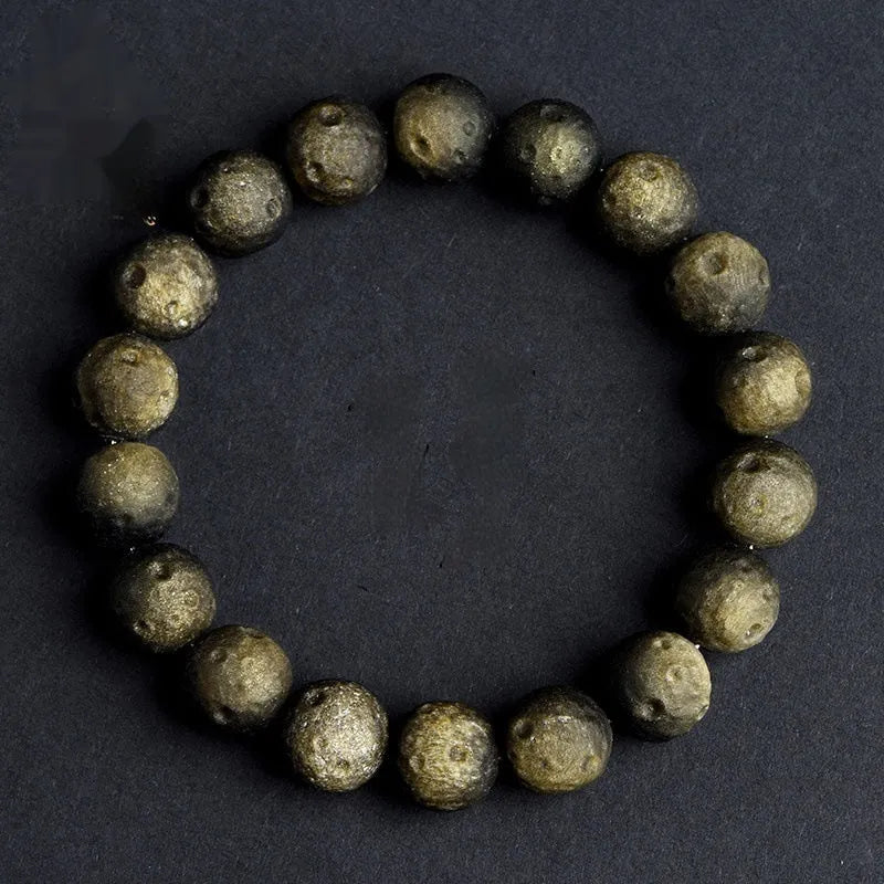 Natural obsidian crater ball bracelet showing distinctive grinding texture on beads