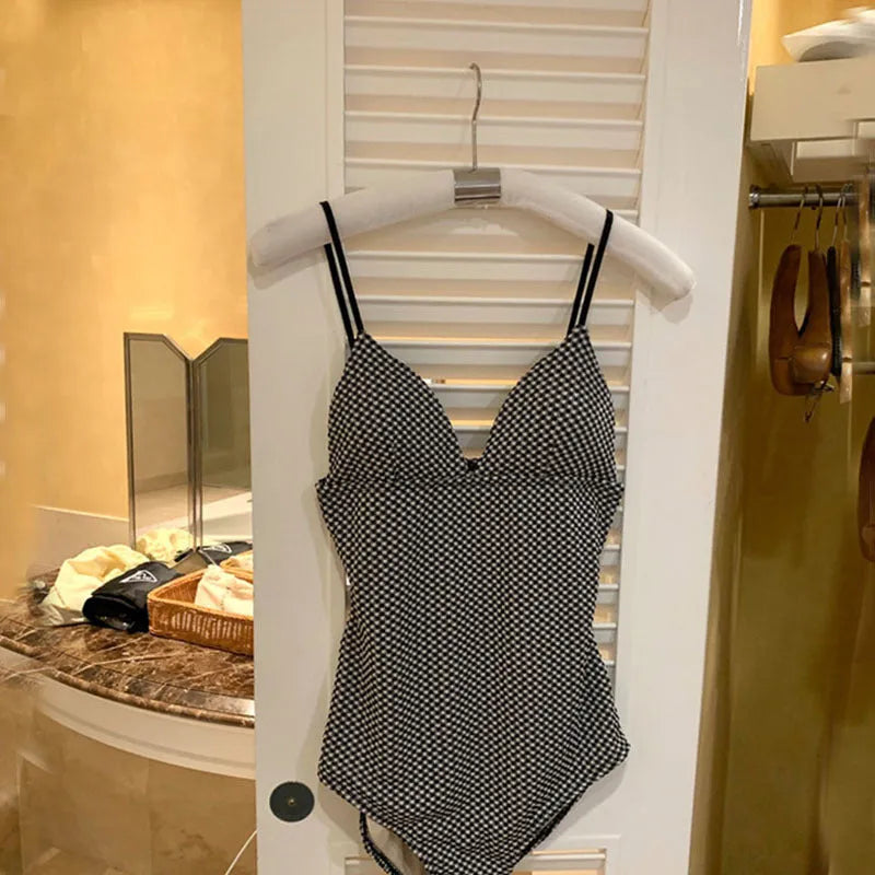 Blue one-piece swimsuit on a model, showing its cover belly and slim chest design.
