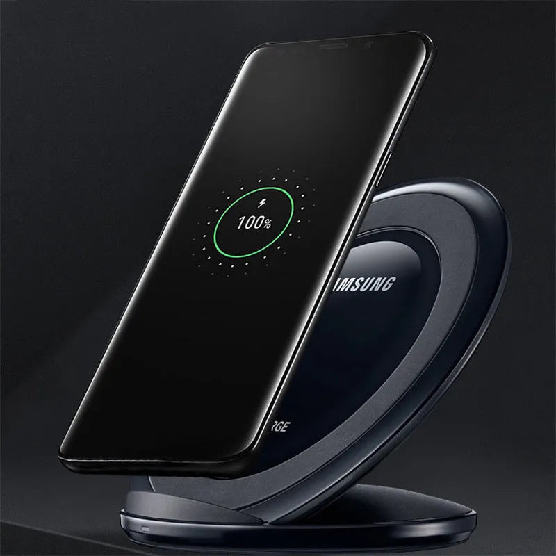 A black or white wireless charging pad for a Samsung Galaxy Note Edge mobile phone on a desk.