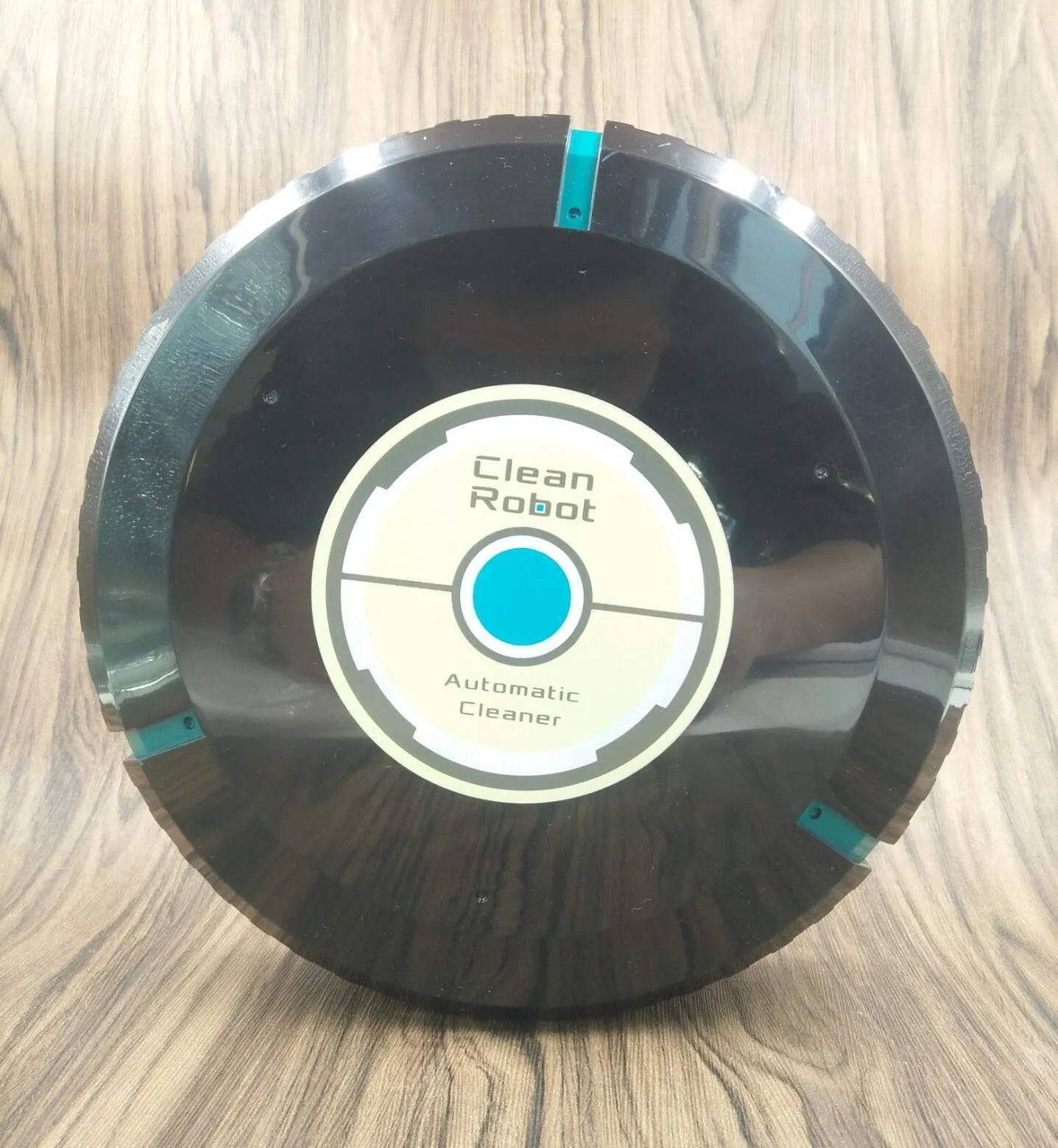Black or white AC robot vacuum cleaner on a wooden floor showing its 23-inch square size and low profile.