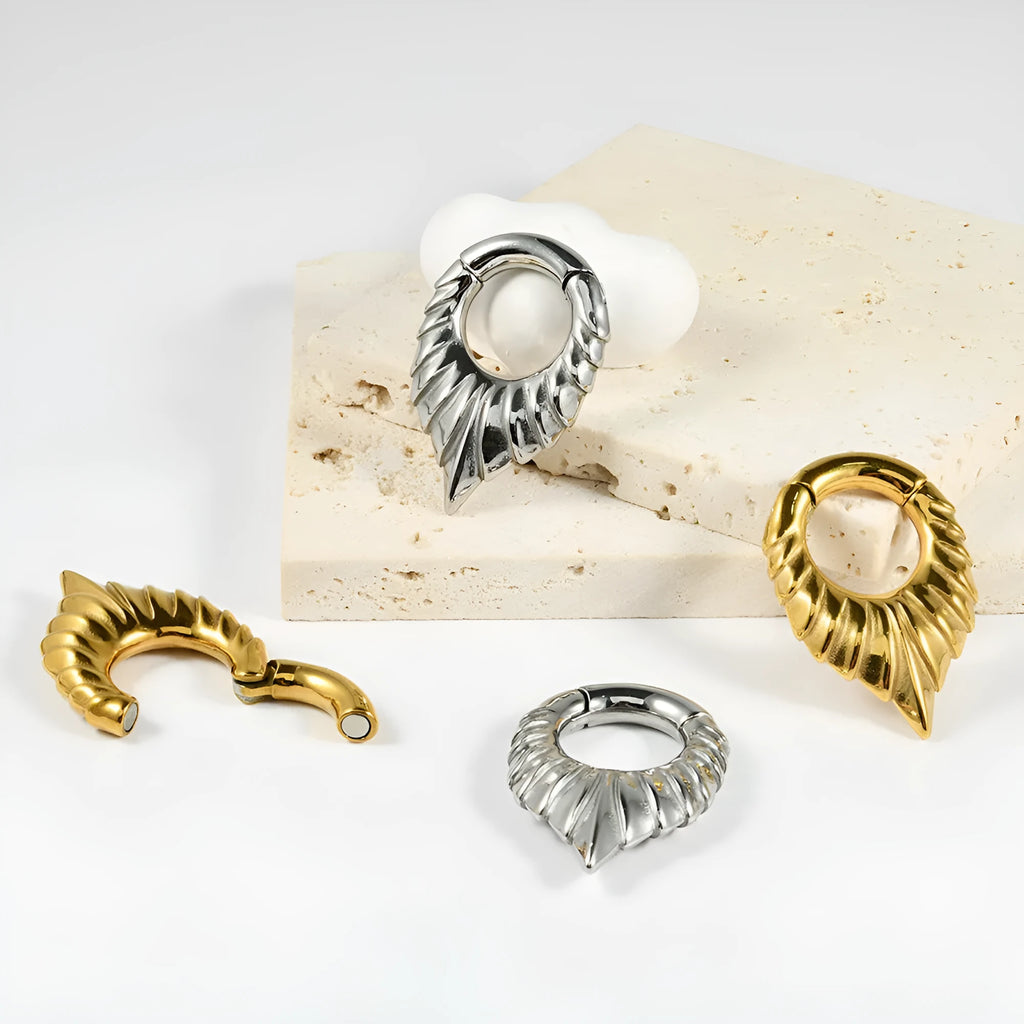 Drop-shaped stainless steel ear extender with totem pattern and hanging egg detail.