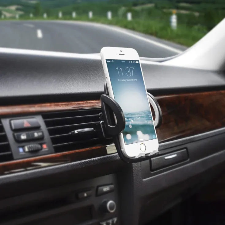 Black plastic car air vent mobile phone holder mounted on a car vent, holding a smartphone.