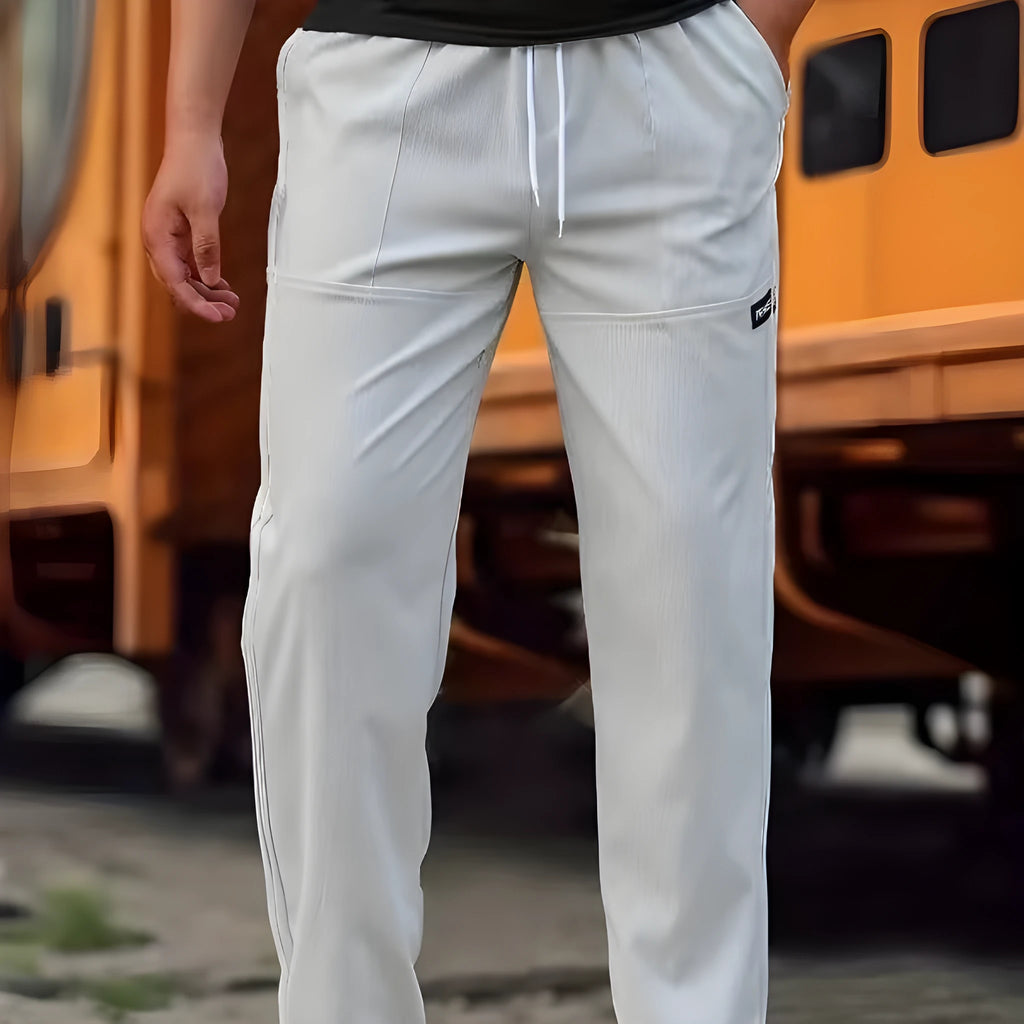 Men's polyester trousers in light grey, shown flat, with a size label indicating S-XXXL range.