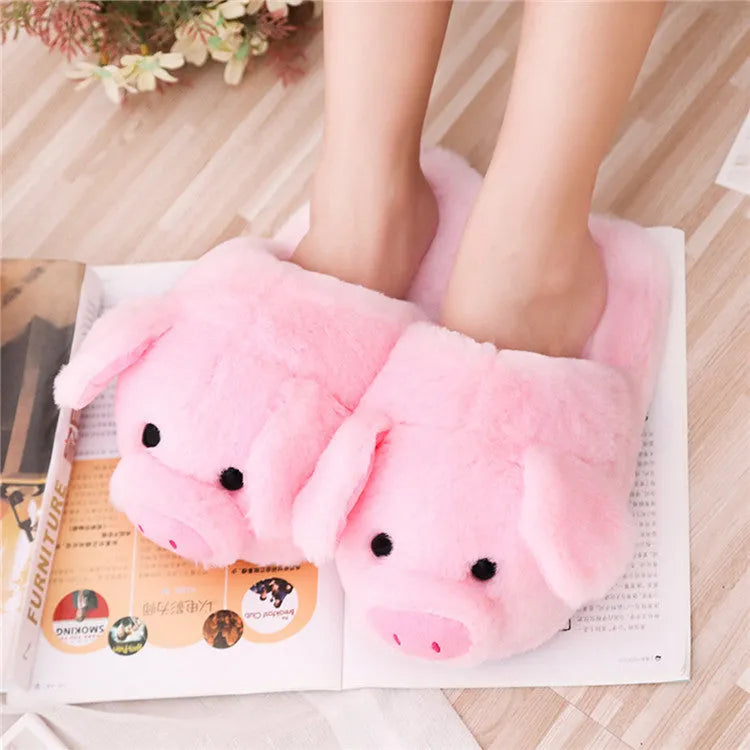 Pink plush floor slippers with a cute pig design on the upper, shown from a side view.