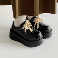 Women's matte black retro ankle boots with a thick rubber sole and buckle fastening on the side.