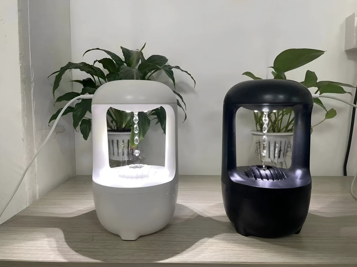 White anti-gravity humidifier with upward-flowing water droplets on dark surface