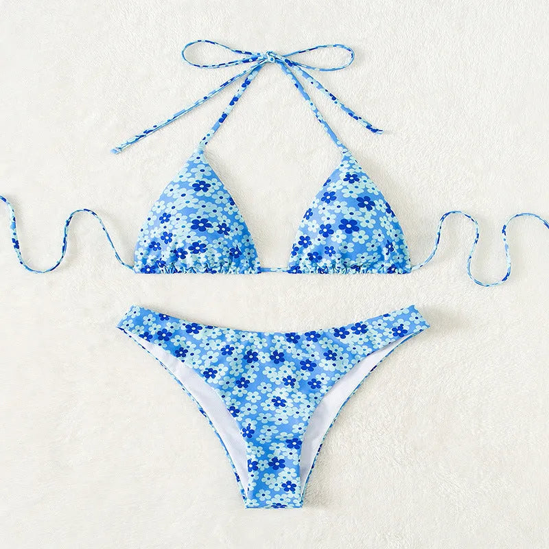 Women's blue printed swimsuit with lace-up front and high split leg shorts.