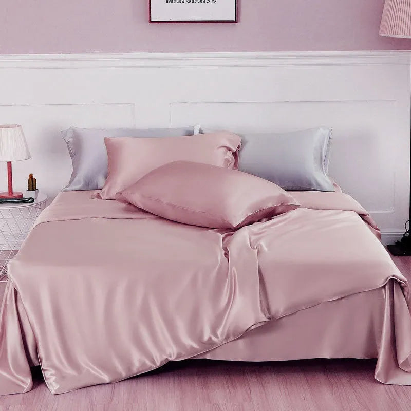 Solid colour silk duvet cover shown in Lotus Pink, laid flat on a bed.