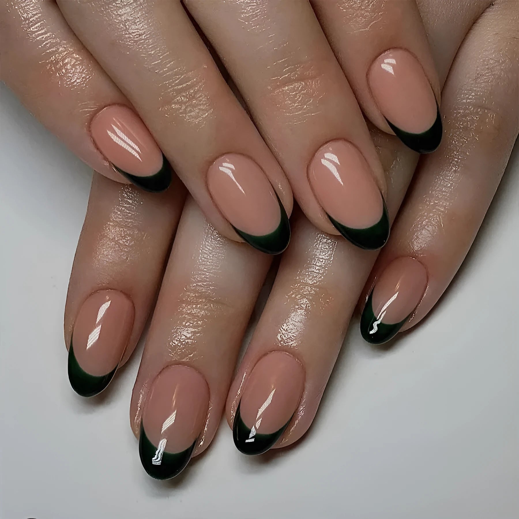 Black French tip false nails in short almond shape, 24 piece set on a white background.