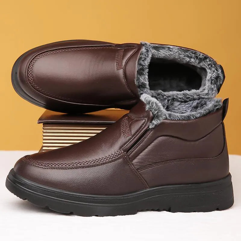 Men's black fleece-lined winter slip-on shoes with a non-slip rubber sole on a wooden floor.