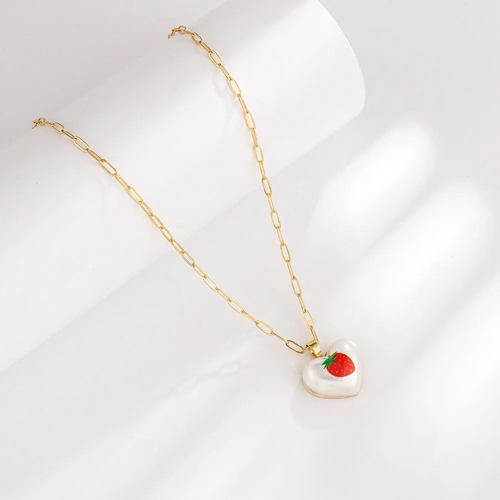Adjustable heart necklace showing geometric fruit pendants: apple, pineapple, strawberry, cherry, and pear.