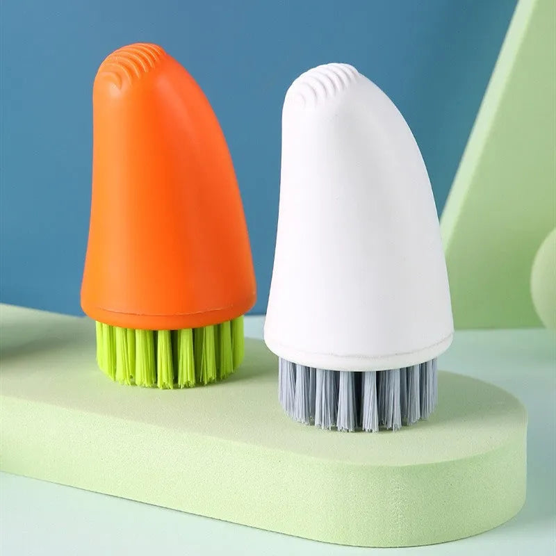 Carrot-shaped nylon kitchen cleaning brush on a white background, shown in orange and white colour options.