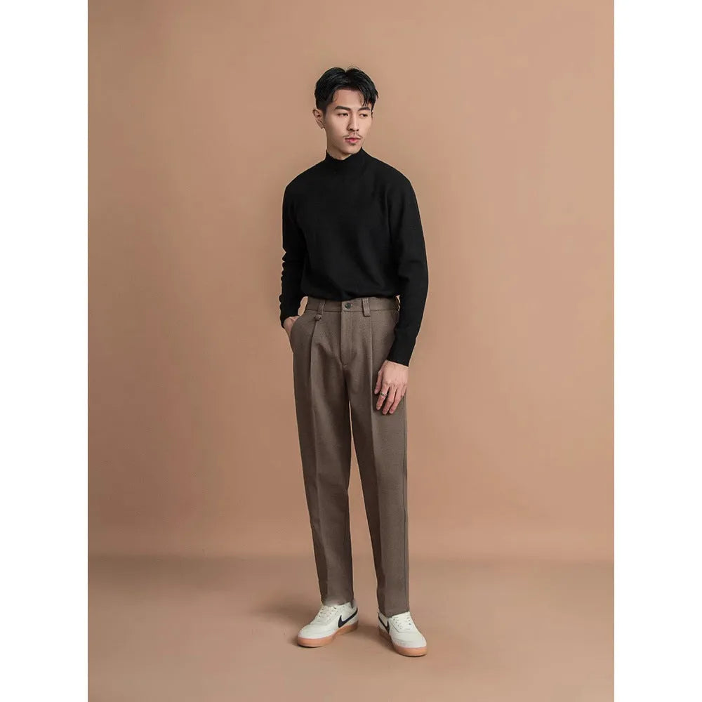 Men's straight-leg casual trousers in black, shown in a light business style setting.