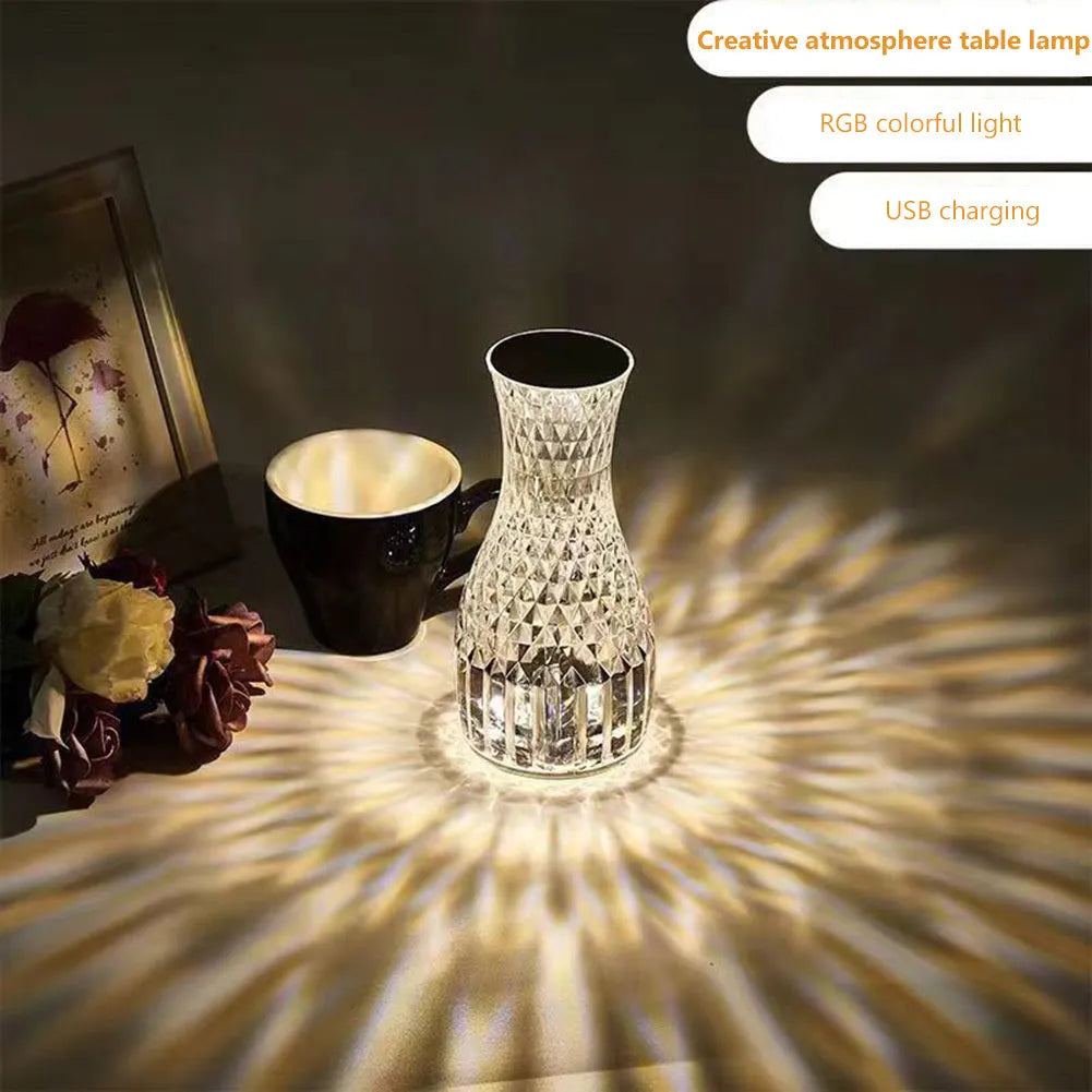 Vase-shaped transparent crystal table lamp with LED colour-changing lights on wooden surface