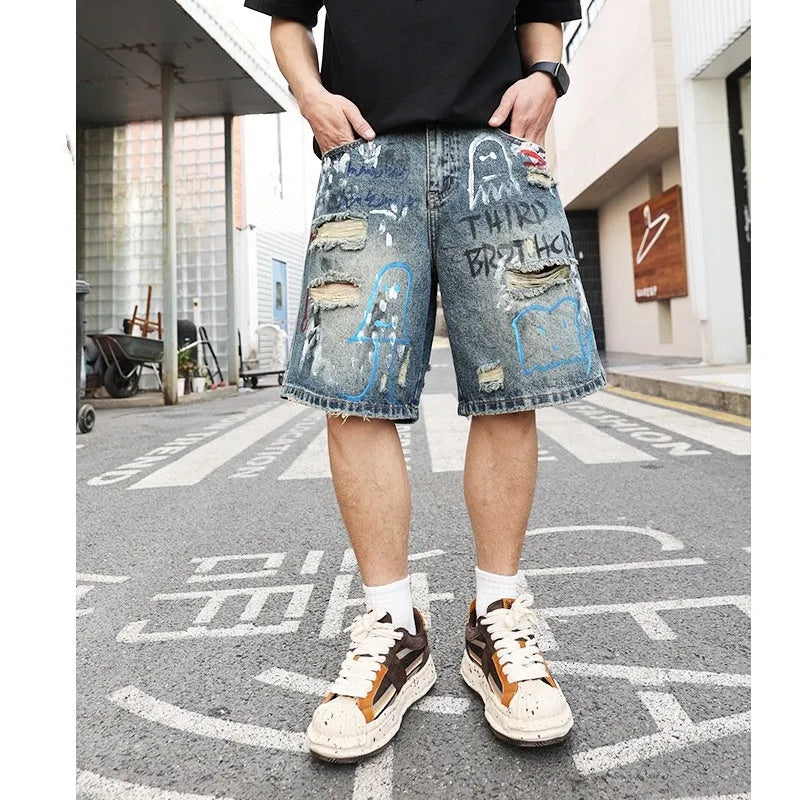Blue distressed denim shorts with graffiti detail and ripped styling on mannequin