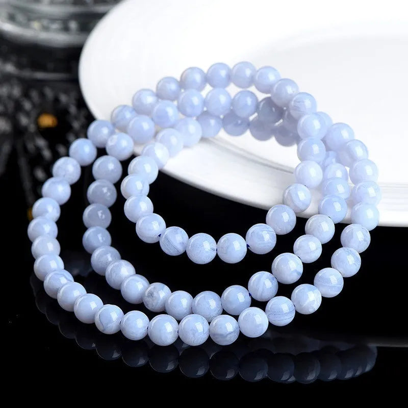Blue multi-circle patterned agate bracelet with scattered 6-6.8mm beads and Ruyi design detail on a white background.