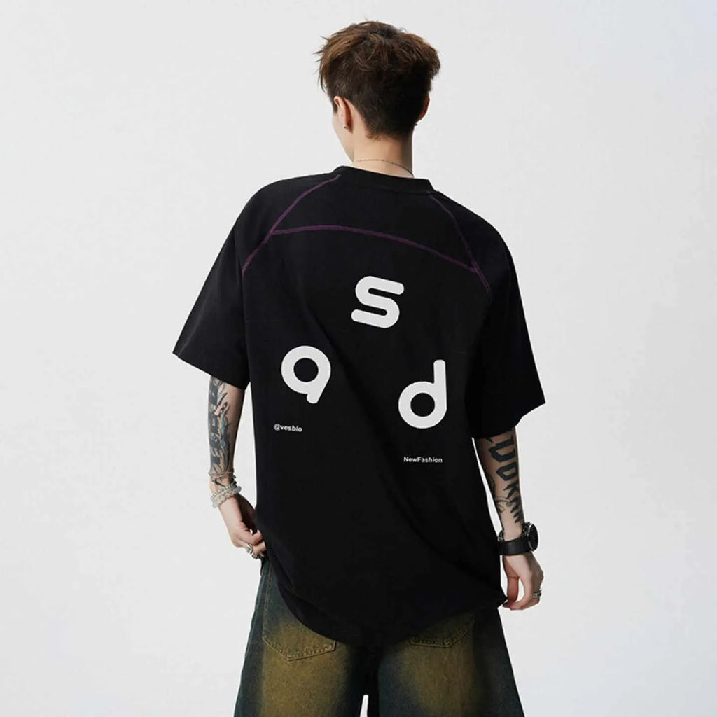 Man wearing a loose fit black cotton t-shirt with a letter print on the chest.