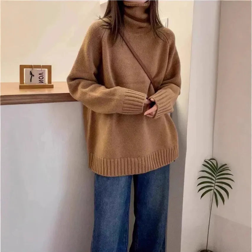 Women's loose grey turtleneck sweater with a thick, textured curling pile collar.