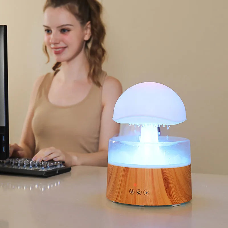 White cloud-shaped humidifier emitting mist with multi-coloured lighting and remote control