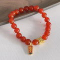 Women's red agate bracelet with manual Chinese dragon and lucky bag designs.