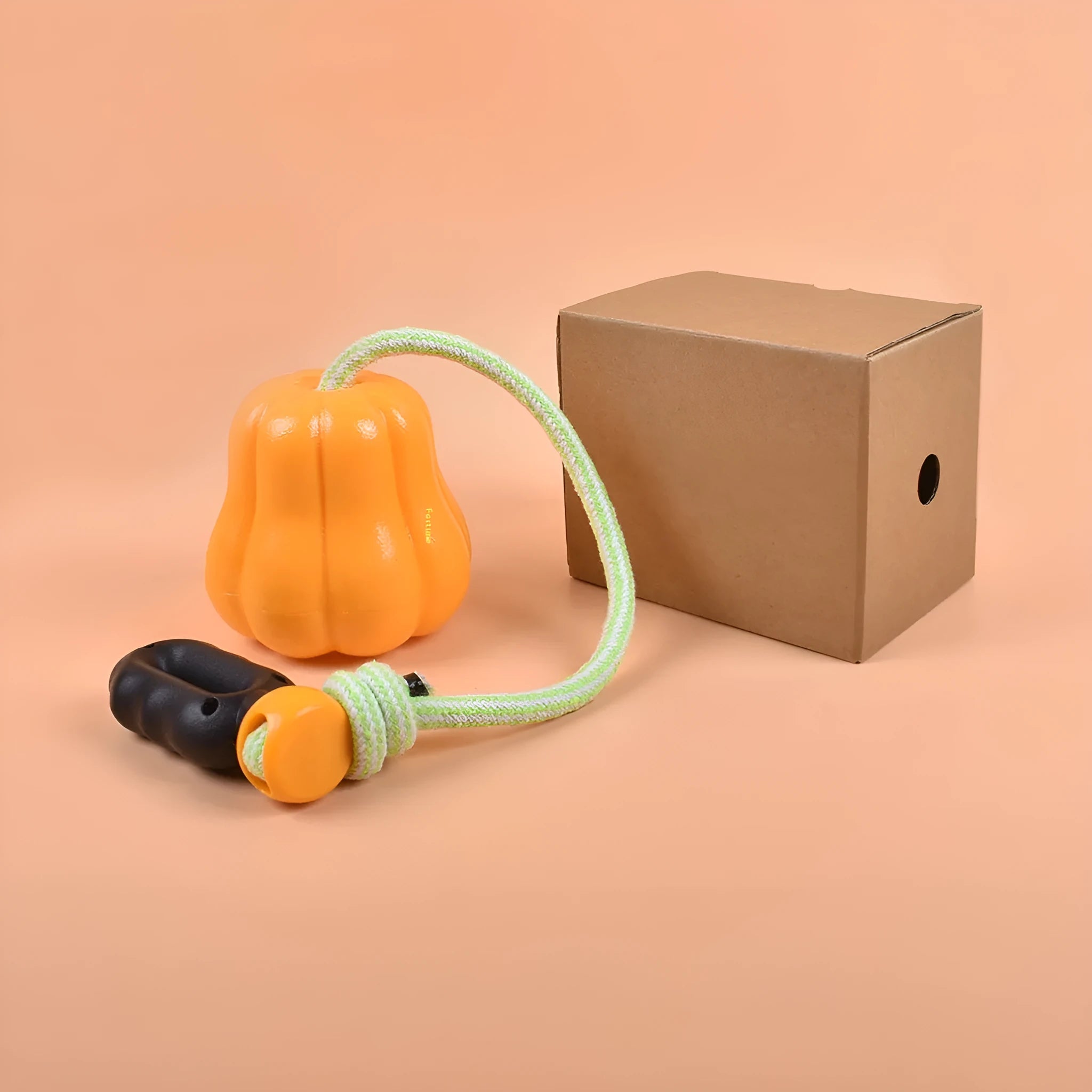 Orange plastic molar-shaped dog toy with rope attachment for chewing and fetch games