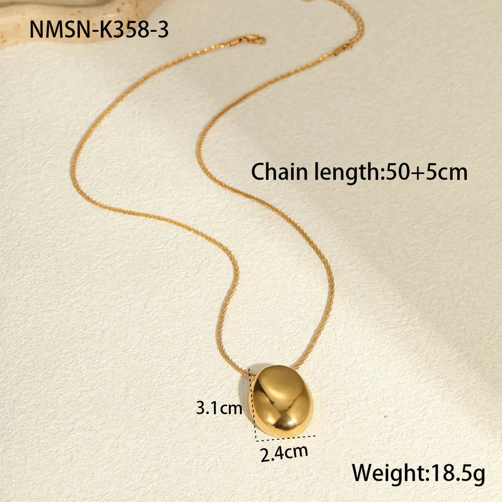 Gold geometric pendant necklace with adjustable chain on jewellery display