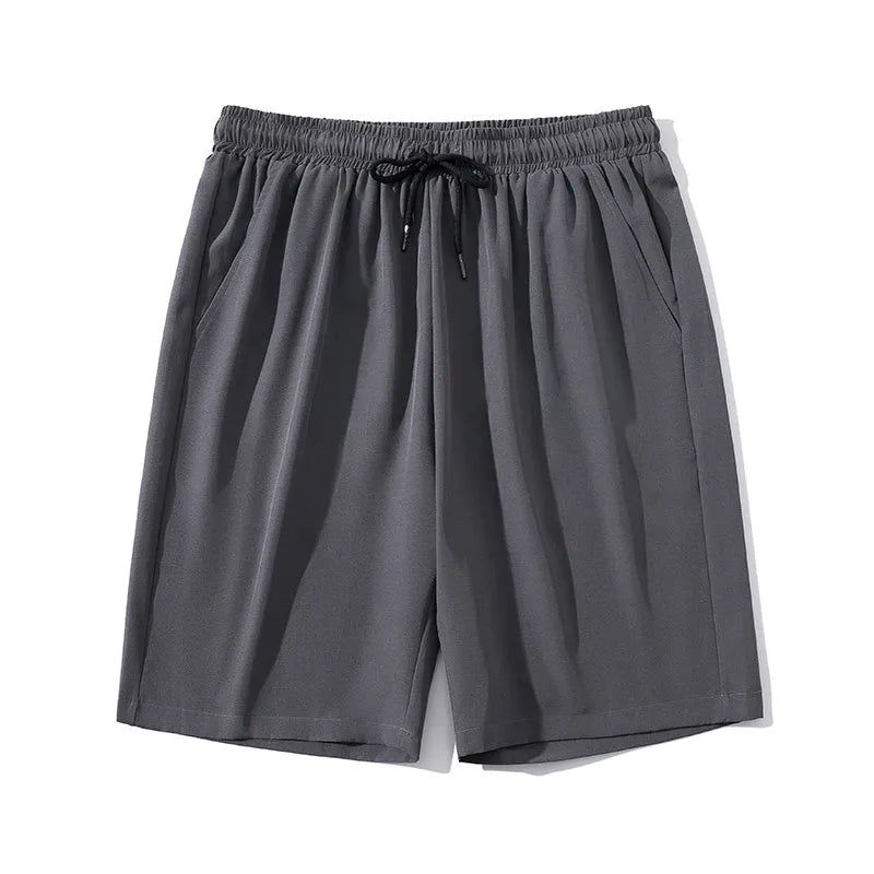Man wearing grey cropped nylon ice silk sports pants with a straight-leg design on a beach.