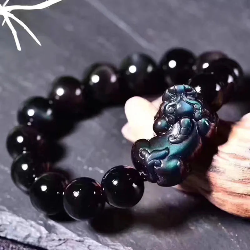 Natural ice colour obsidian crystal bracelet with spherical beads on a neutral background.