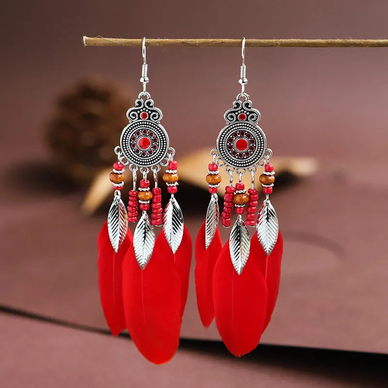 Feather-shaped round drop alloy earrings with leaf design in electroplated finish, showing Bohemian style jewellery.