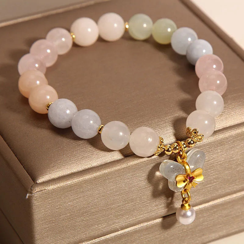 Close-up of a women's adjustable crystal bracelet with a colourful Morganite butterfly pendant.