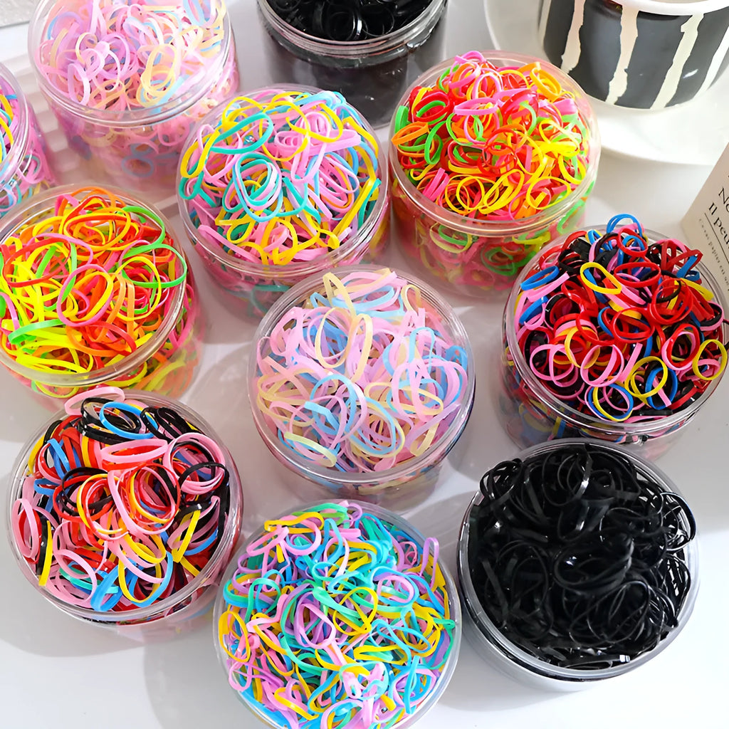 Multi-colour TPU baby hair elastics for toddlers stored in a clear reusable container, showing small and large size options.