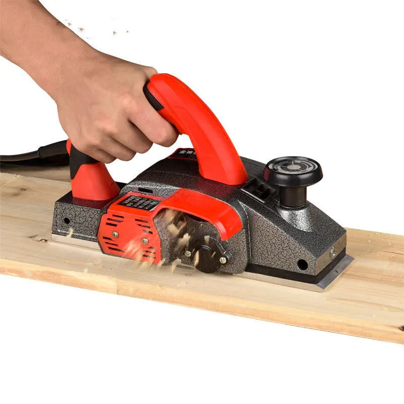 Red desktop electric planer with aluminium housing for woodworking showing 82mm planing width