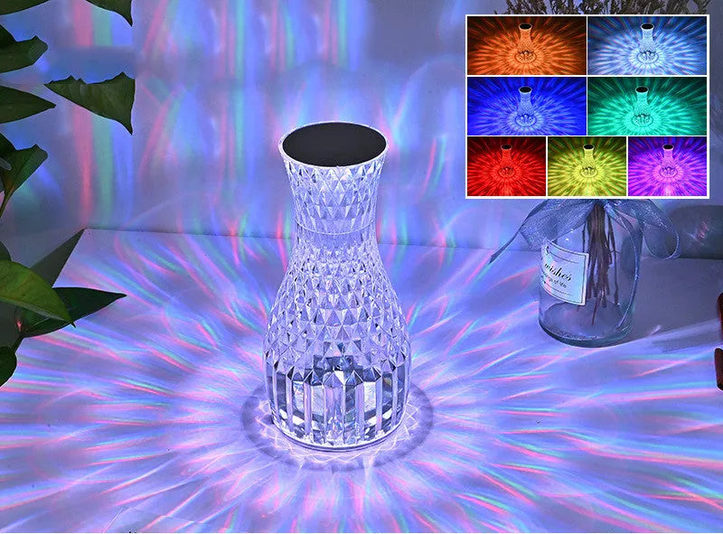 Vase-shaped transparent crystal table lamp with LED colour-changing lights on wooden surface
