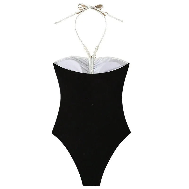 Women's black and white pearl spaghetti strap one-piece swimsuit with sleeveless slimming design.