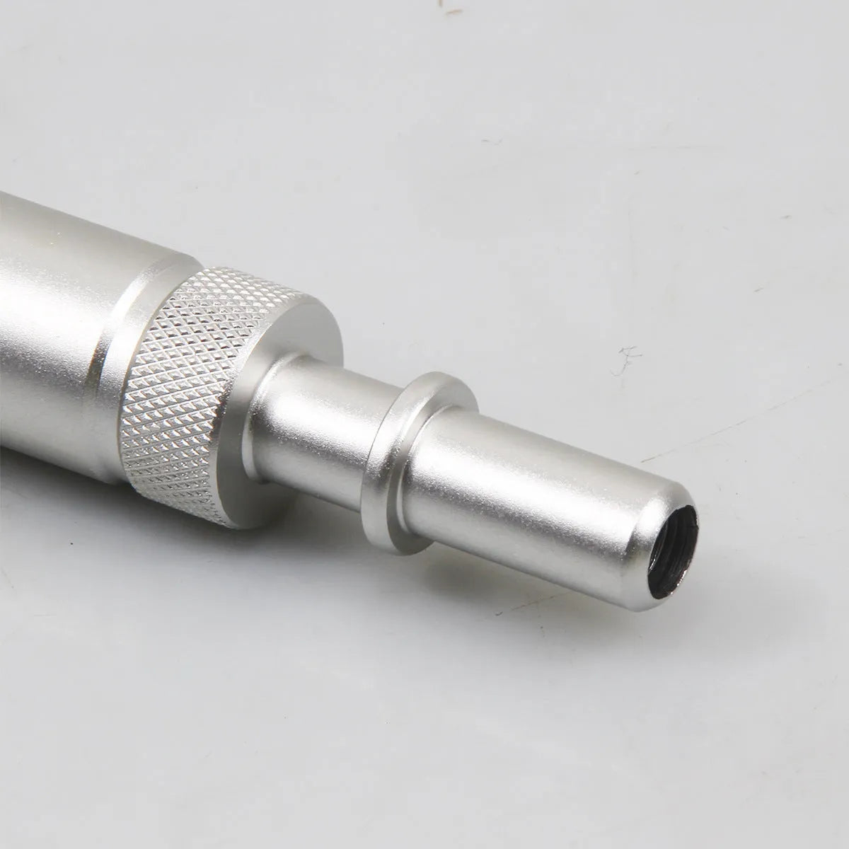 Silver metal transmission refuelling joint for automotive workshop use.
