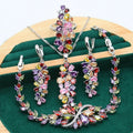 Retro style jewellery set showing necklace with floral pendant, bracelet, earrings, and ring in olive and purple colours.